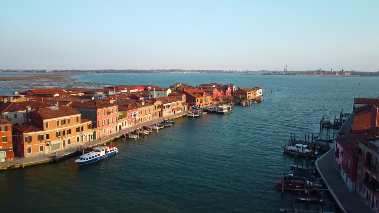 Murano Island seen from the drone at sunset with Venice in the background. Artistic glassworks of Murano overlooking the Venetian lagoon.