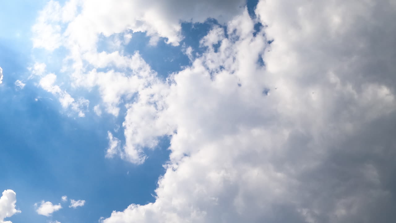 Lovely little white clouds turning into a grey cloudscape. Rain clouds accumulation in the atmosphere. View from below. Timelapse.