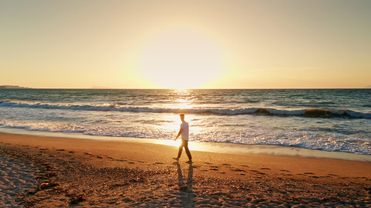 해가 지면 해변을 고 있는 남자