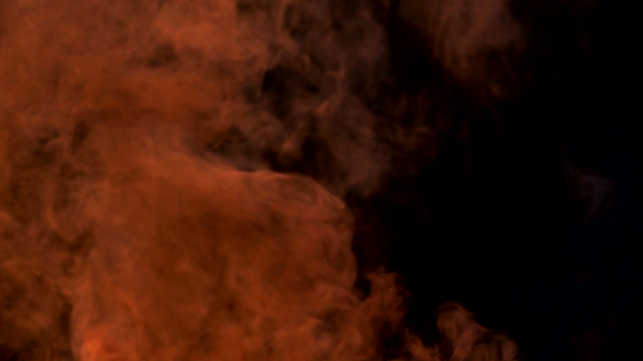 fuego en cámara lenta quemando bolsa de basura en el amanecer fondo oscuro.