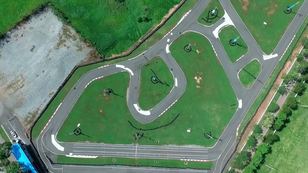 Timelapse aereo con drone dall'alto diurno che mostra le ombre delle nuvole che si muovono su un circuito professionale di go-kart nella Repubblica Dominicana.