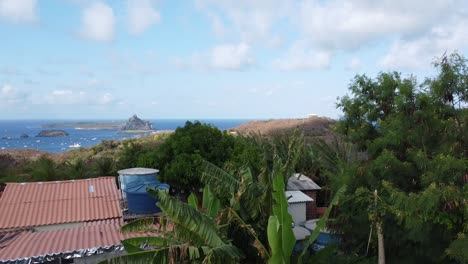 Drohne-Steigt-Aus-Den-Kokospalmen-Und-Zeigt-Die-Festung-Fernando-De-Noronha,-Boote-Und-Meer,-Paradiesische-Aussicht