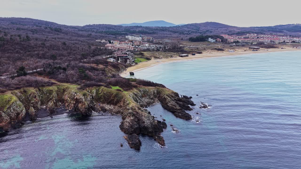 Kystlinje med udsigt over stenede kyster og roligt vand nær et strandområde