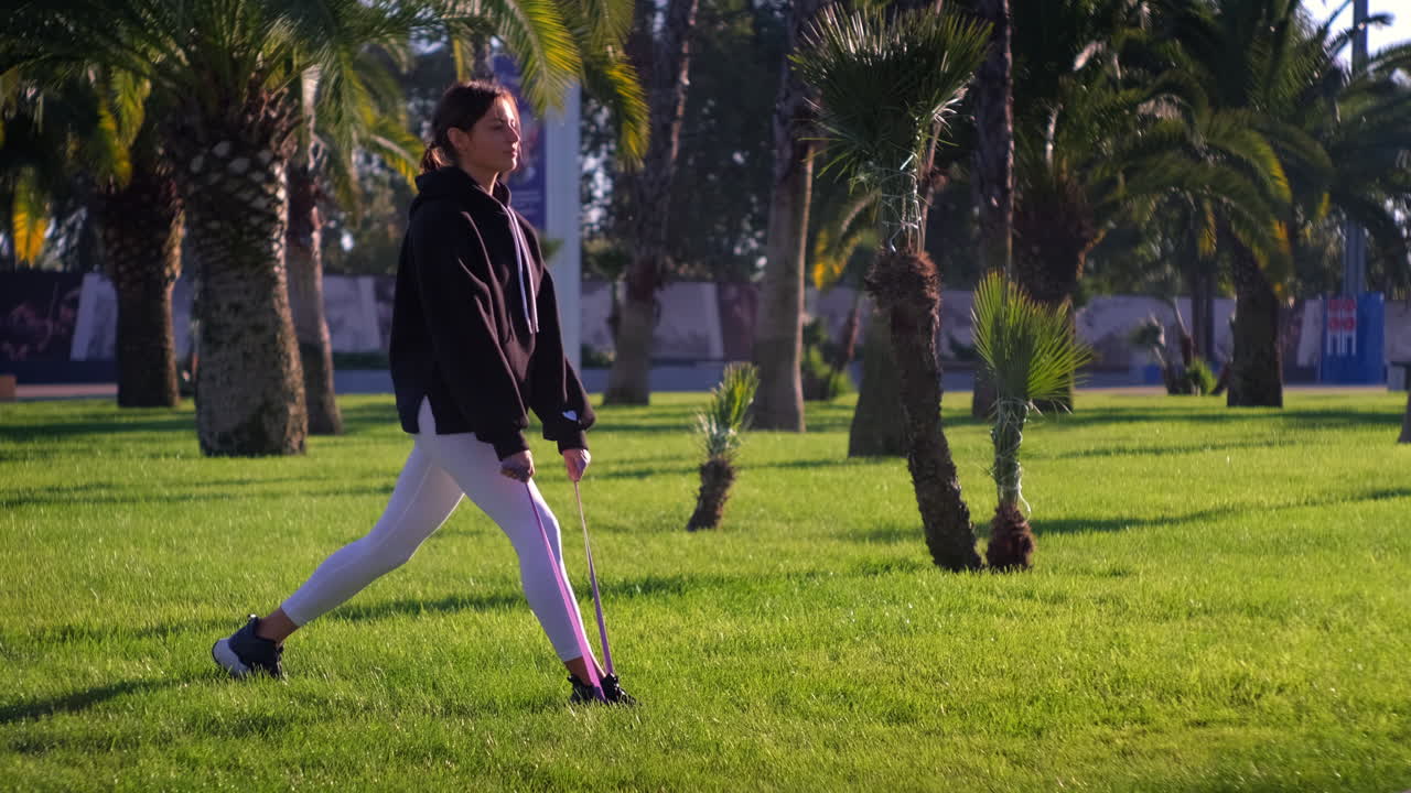 mujer haciendo ejercicio al aire libre con banda de resistencia