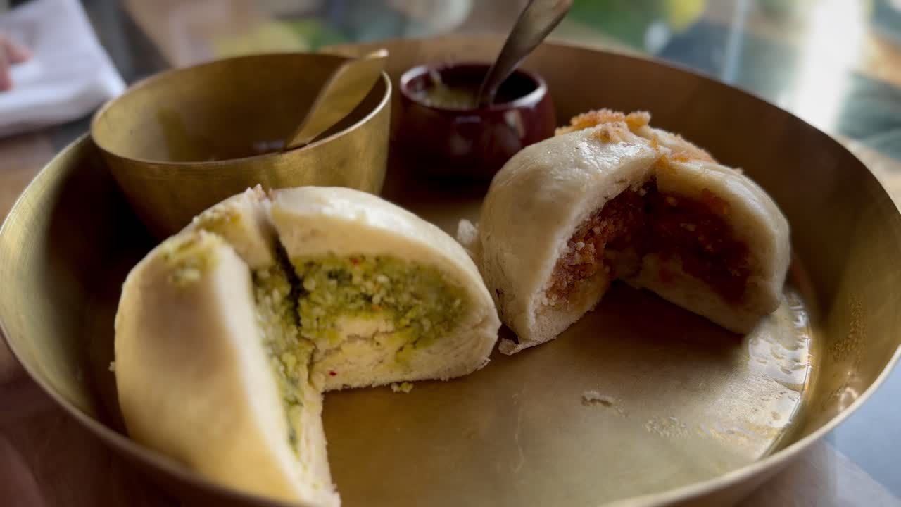 Plate of Kashmiri Siddu bread with green and orange fillings, chutney on side