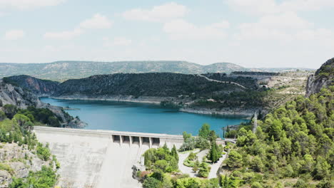 tilt down aerial shot of a massive dam with road on it, located in spain