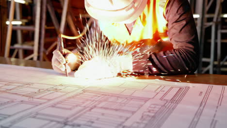 construction worker reviewing and welding plans