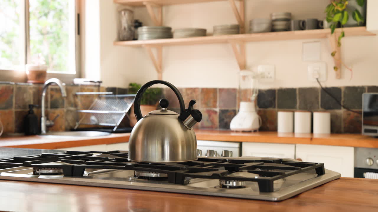Stainless steel kettle on stove in cozy kitchen with natural light