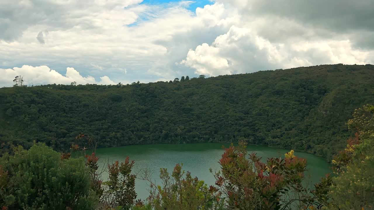 Scenic view of Laguna de Guatavita, a serene lake encircled by dense green forests