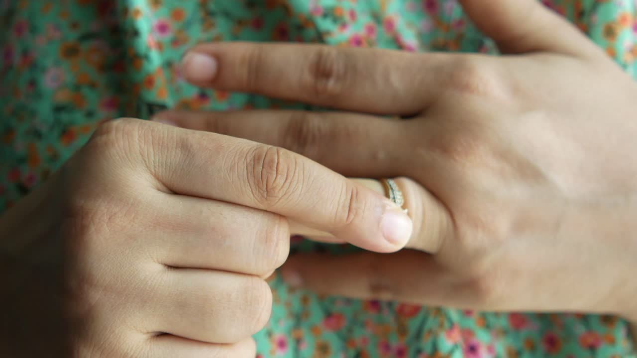 mujer que se pone o se quita el anillo