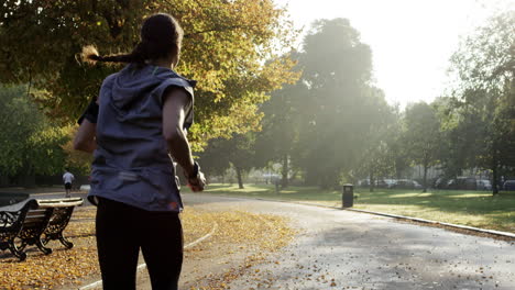 runner woman running in park exercising outdoors fitness tracker wearable technology