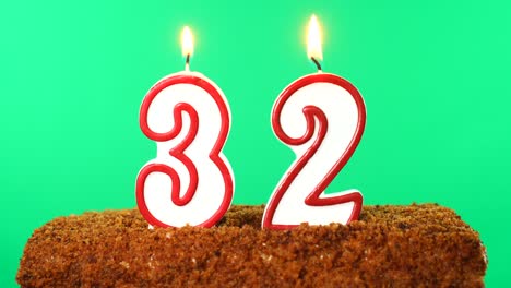 cake with the number 32 lighted candle. chroma key. green screen. isolated