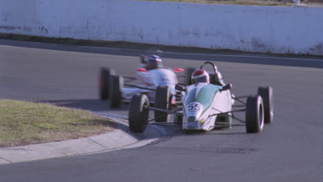 two racing cars round a bend in the racetrack