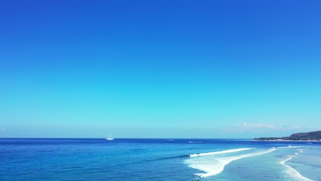 wonderful scenery in the philippines of wide blue ocean and waves toward the shore during sunny day - wide shot