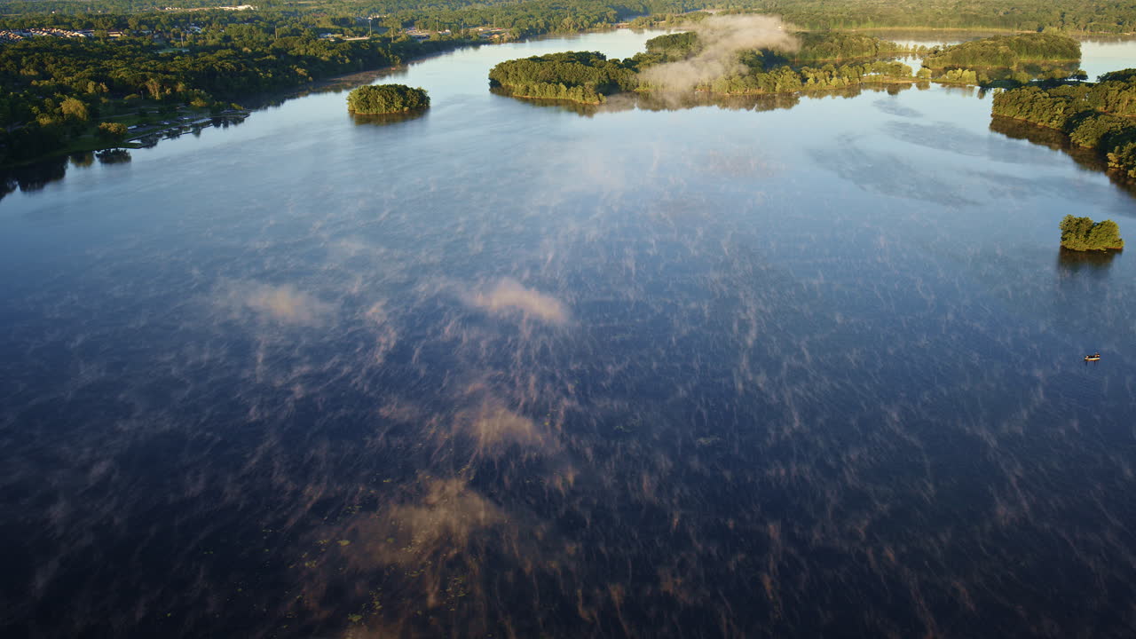 Drone shot flying over fishing boats in foggy river