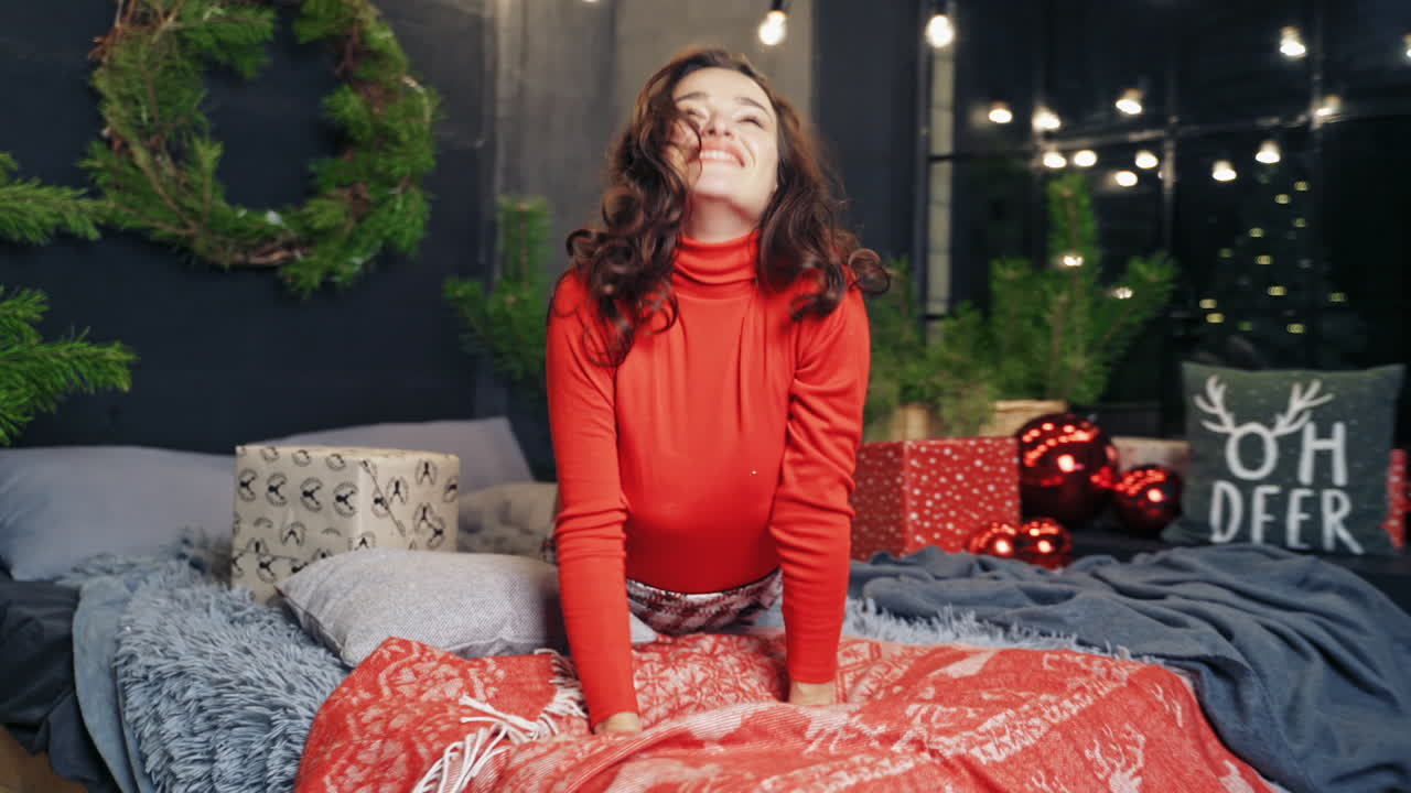 Portrait of young beautiful girl. Beautiful woman sitting on the bed in cozy interior
