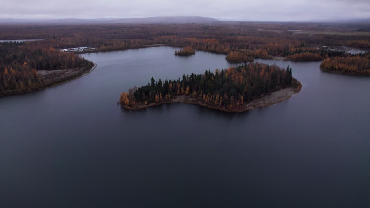 Ripresa aerea con drone di un'isola con colori autunnali sugli alberi al Lago Chena, Alaska