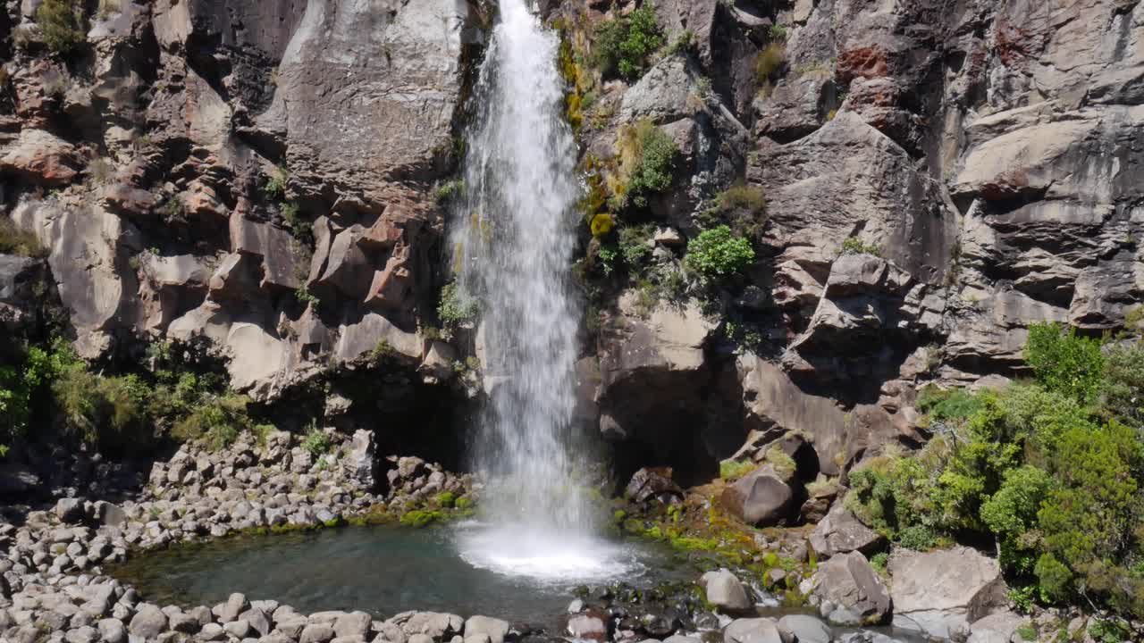la cascada del acantilado escarpado aterriza en una pequeña piscina rocosa verde, mt ngauruhoe