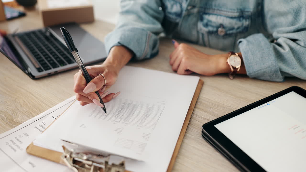 Woman working at a desk with paperwork and technology