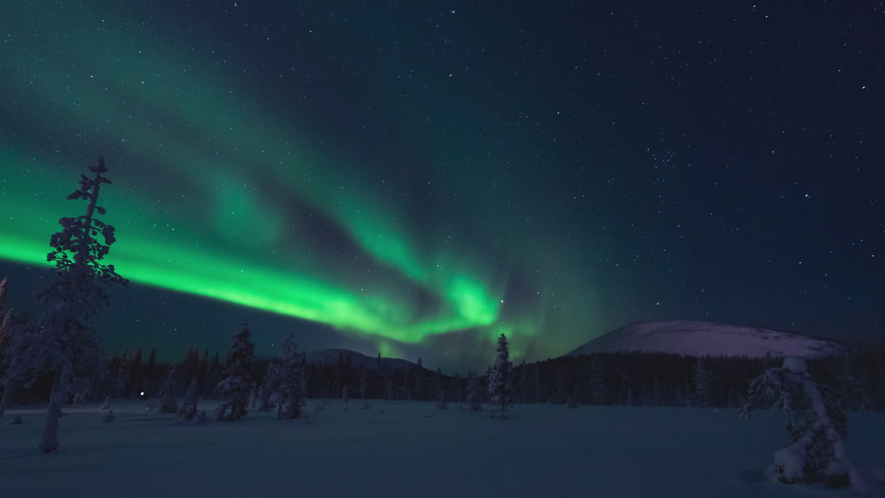 timelapse real de la aurora boreal o la aurora boreal bailando en el cielo nocturno sobre un paisaje invernal con árboles nevados y montañas caídas en laponia finlandia