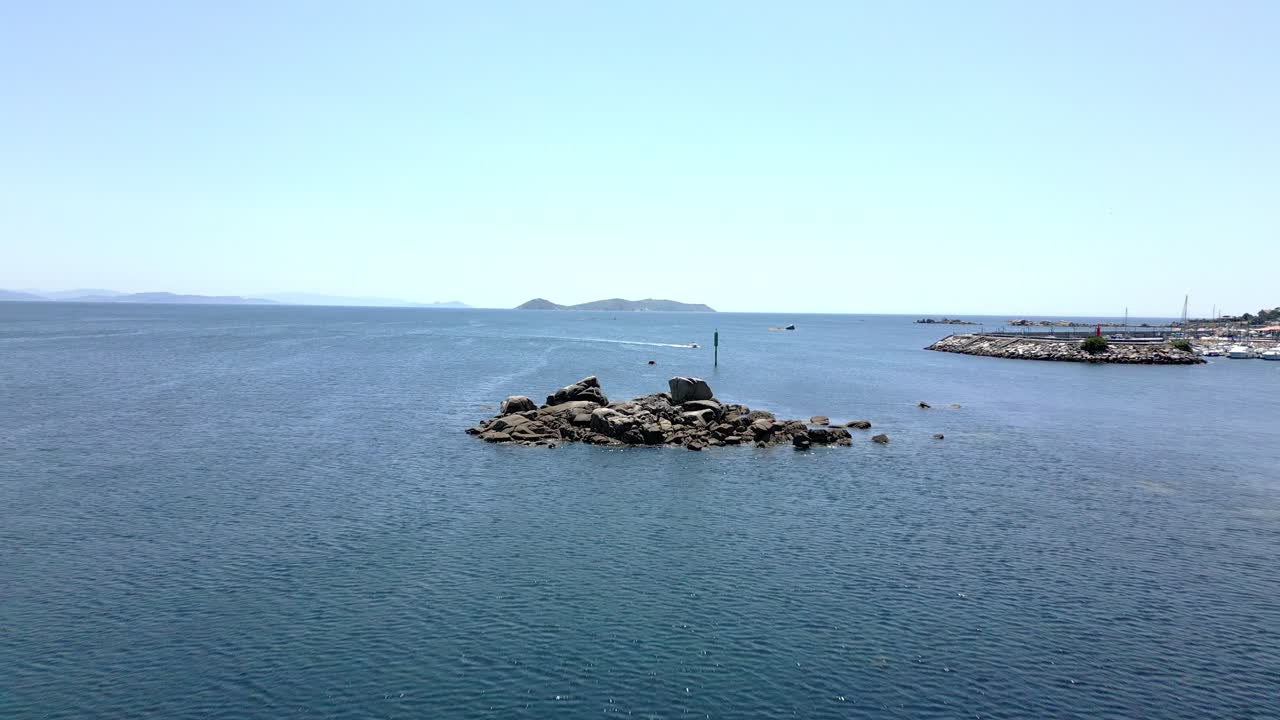 지평선에 마리나와 섬이 있는 평화로운 바다의 드론 영상