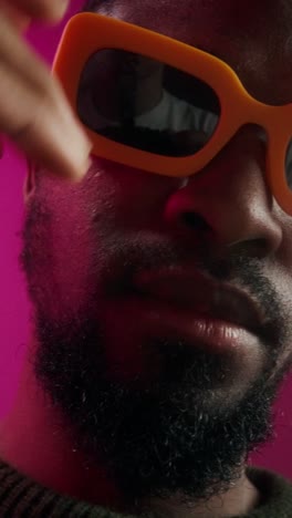 close-up portrait of a man wearing orange sunglasses