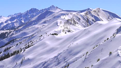 deep powder snow winter panorama aspen highlands bowl ski resort backcountry high alpine steep terrain colorado castle conundrum peak maroon bells wilderness elk mountain range blue sky sunny zoom out
