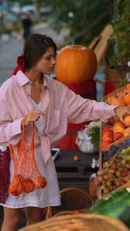 woman shopping for peaches at a farmers market