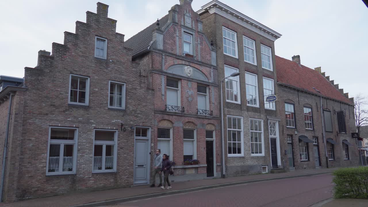 Couple walking through old dutch Village, IJzendijke, Netherlands