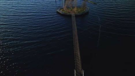 flying above footbridge over island and viewing deck at sea, aerial