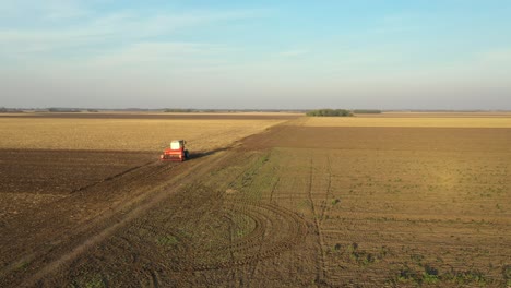 movimiento en órbita de dolly en vista aérea superior del tractor como arrastrando una máquina de siembra sobre el campo agrícola, tierras de cultivo