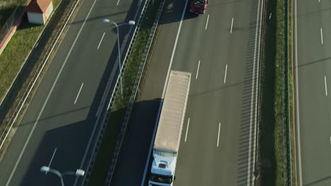 Weißer-LKW-Fährt-Auf-Einer-Autobahn-Bei-Mäßigem-Verkehr-Durch-Unterführung---Kamerafahrt