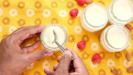 preparing homemade yogurt parfaits with raspberries and almonds