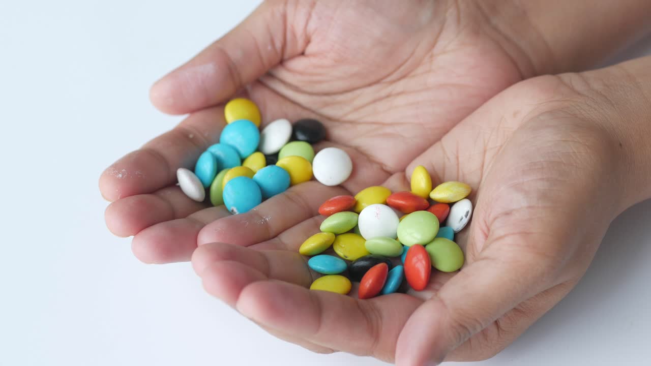 다채로운 사탕을 들고 있는 손