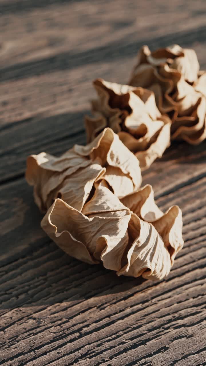 Close-up video of dried leaves on a wooden surface, captured from a low angle
