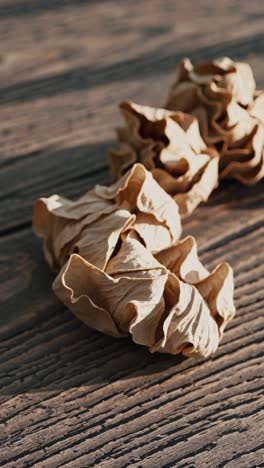 close-up video of dried leaves on a wooden surface, captured from a low angle