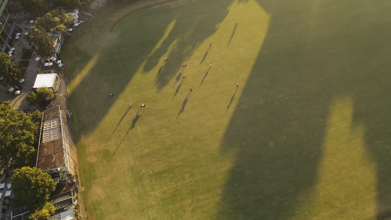 부에노스 아이레스에서 해가 지는 동안 녹색 필드에서 말과 함께 폴로 게임 - 공중 상단 아래 느린 동작