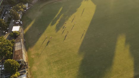 Polo-Game-with-horses-on-green-field-during-sunset-in-Buenos-Aires---Aerial-top-down-slow-motion