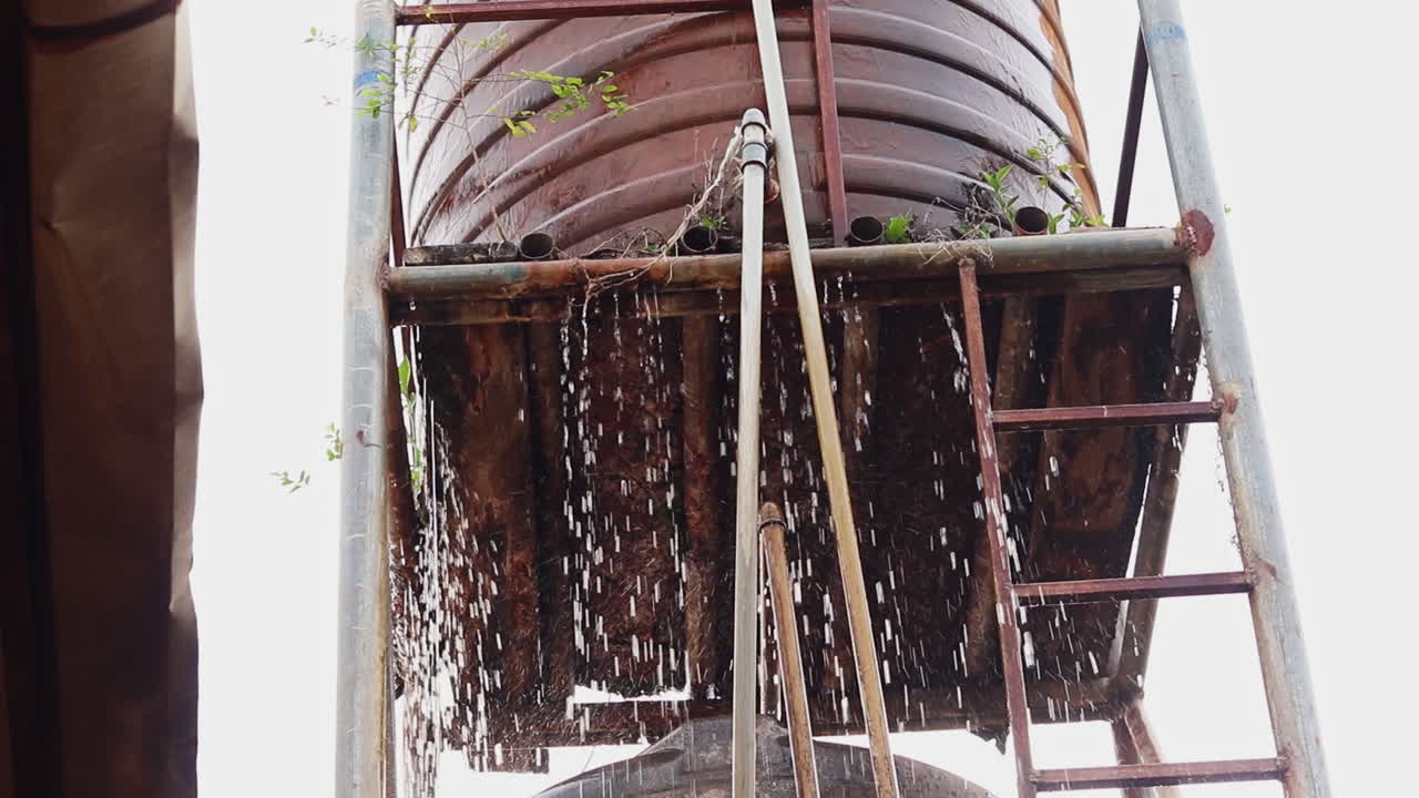 Leaking rusty water tank with ladder