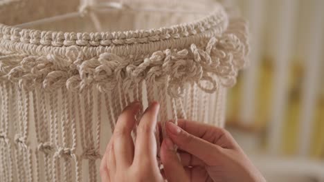 home hobby, knitting macrame. women's hands knit an ornament with thick threads.