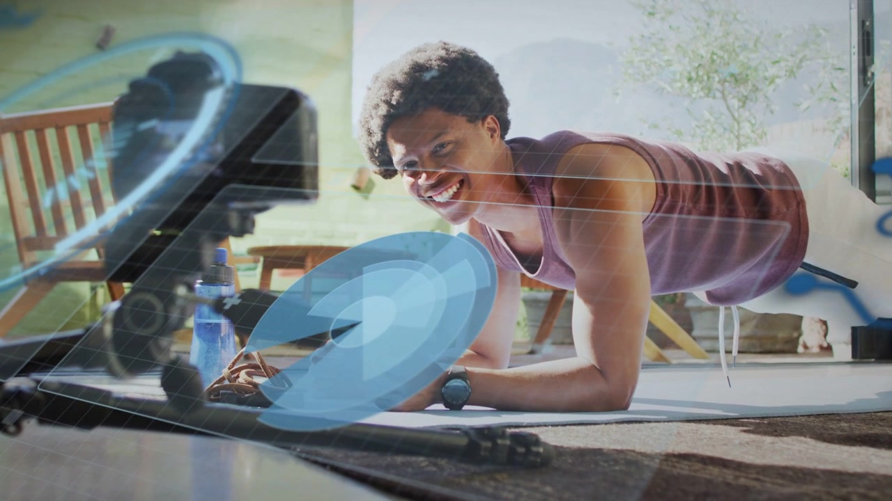 Vertical video: Camera rig recording man in tank shorts holding plank on mat at home, blue overlay