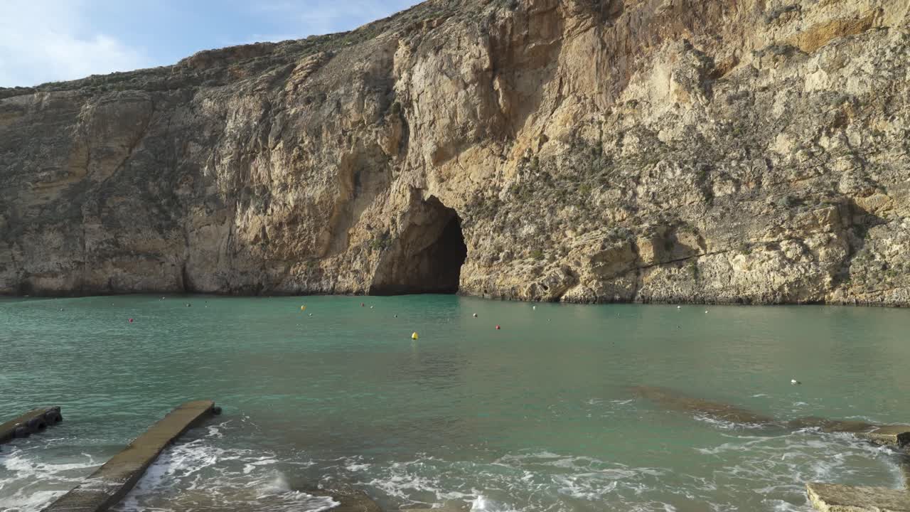 cueva marina en el mar interior cerca de dwerja en un día soleado en invierno con boyas flotando en la superficie del agua