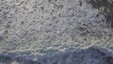 Aerial-Drone-Shot-of-Beach-with-Crashing-Waves-and-Rocks