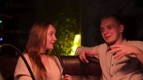 couple enjoying hookah in a lounge bar