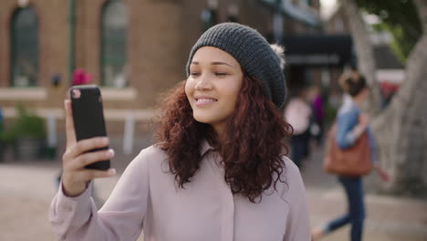 Retrato-De-Una-Bonita-Chica-De-Raza-Mixta-Con-Gorro-Posando-Tomando-Una-Foto-Selfie-Usando-Un-Teléfono-Inteligente