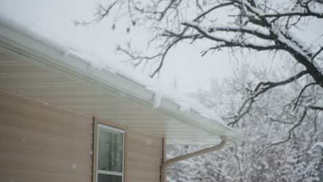 an ice dam building up on a roof near the gutters during snowstorm