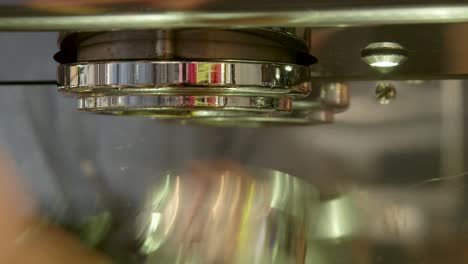 cómo hacer un verdadero espresso italiano: barista girando el filtro en el cabezal de la máquina de café, preparándolo