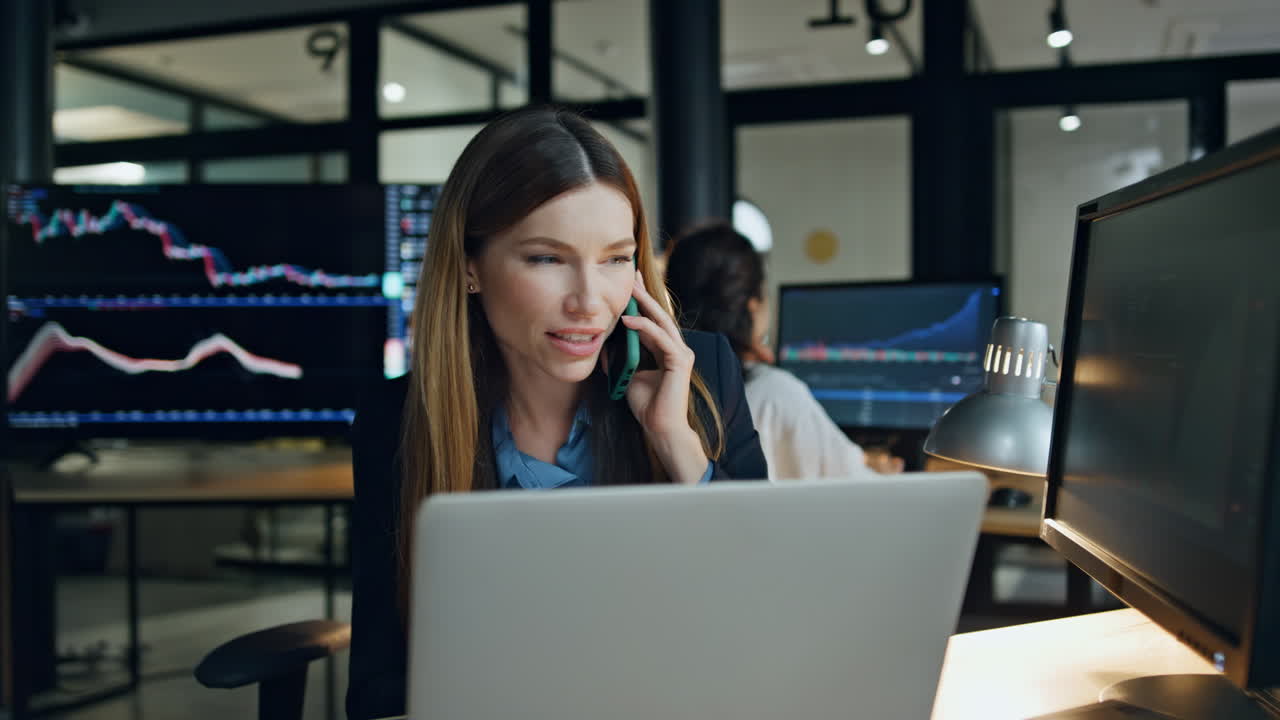 Donna d'affari sorridente che chiama un cliente sul posto di lavoro. Broker professionale impegnato che parla.