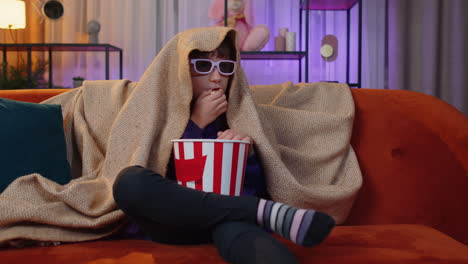 oreteen girl eating popcorn watching interesting tv serial sport game online content on home couch