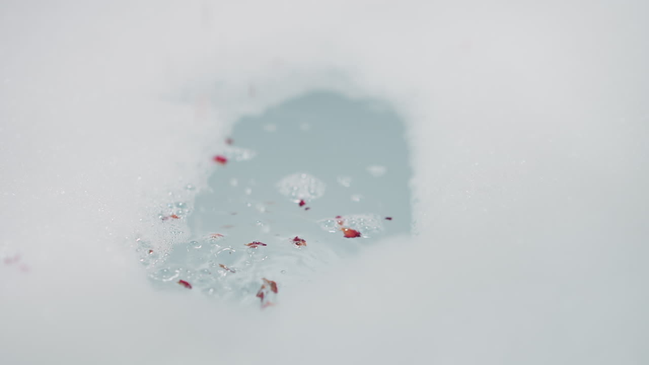 꽃잎과 함께 욕조 소금은 욕조에 가까이 떨어집니다. 가정에서 스파 보살을 위해 건조한 허브와 혼합 된 자연 제품으로 휴식 절차를 준비합니다.